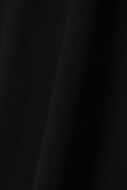 Close-up of black GOTS-certified organic cotton T-shirt fabric texture – Studio Drop