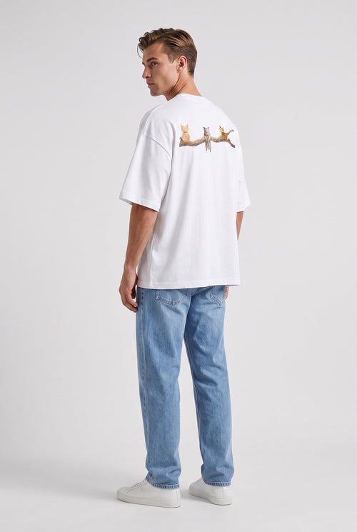 Model wearing Whimsy Tee in white, rear side view – Studio Drop UK streetwear